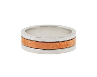 Op de afbeelding: Een zilveren ring met een dunne koperen band.
