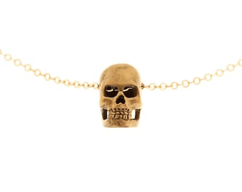 Op de afbeelding: Een gouden ketting met een gedetailleerde gouden schedel hanger.