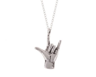 Op de afbeelding: Zilveren ketting met een hanger in de vorm van een hand die het 'Ik hou van je' gebaar in Nederlandse Gebarentaal maakt.
