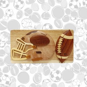 May include: A wooden wall decor featuring a football helmet and a football, both carved from wood with intricate details. The helmet is brown and white, while the football is brown with white stitching.