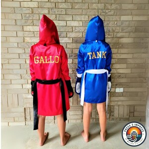 May include: Two satin boxing robes, one red and one blue, with gold lettering. The red robe says "GALLO" and the blue robe says "TANK".