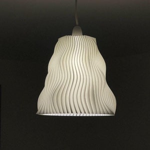 Puede incluir: Una lámpara colgante blanca con una pantalla ondulada y texturizada.
