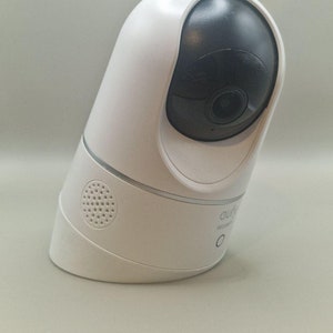 May include: A white home security camera with a black lens and a speaker on the side. The camera is labelled "CUJO Secure".