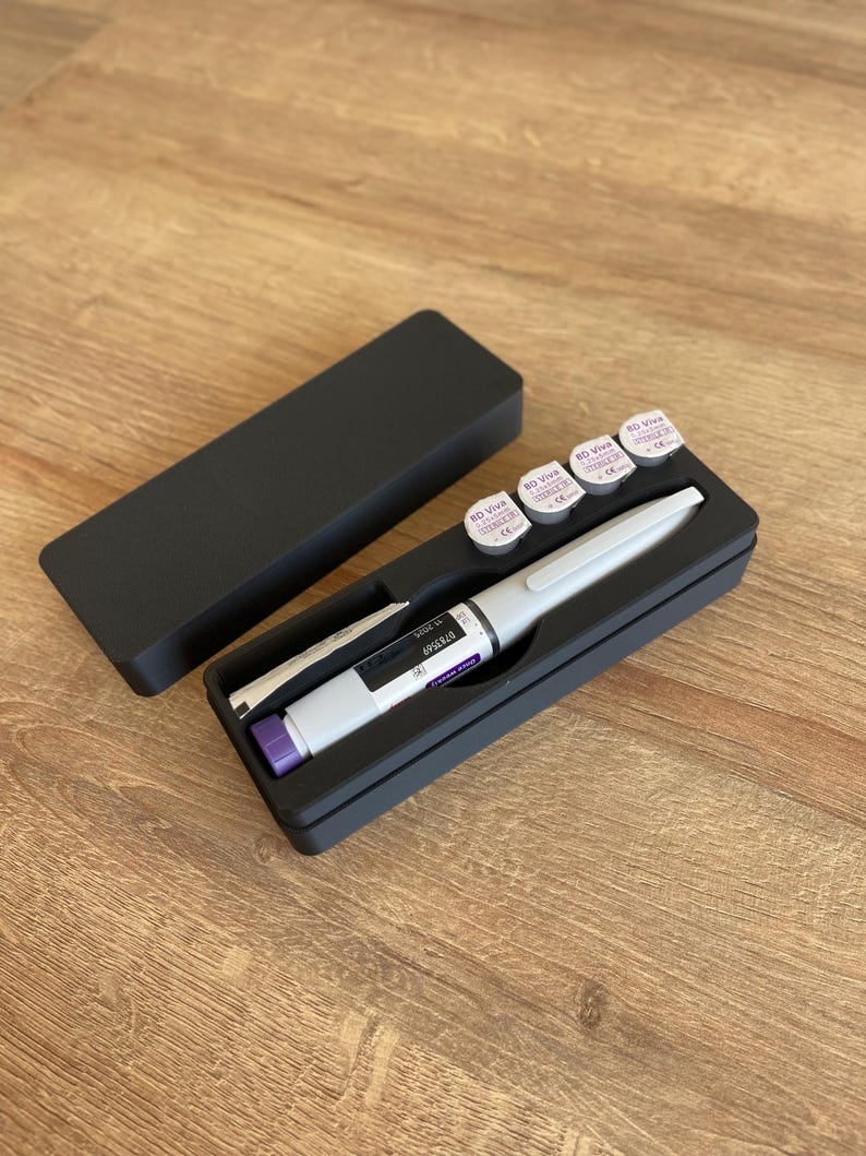 May include: A black case with a white pen and four small round containers with purple labels that say "BD Viva 30G x 1/2", "BD Viva 30G x 1/2", "BD Viva 30G x 1/2", and "BD Viva 30G x 1/2".