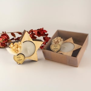 Könnte beinhalten: Ein Set aus drei Keramikbechern mit einer gesprenkelten, cremefarbenen Glasur. Jeder Becher hat ein anderes handgemaltes Design: ein blaues und grünes Blatt, eine gelbe Blume und eine rote Beere. Die Becher haben ein schlichtes, modernes Design.