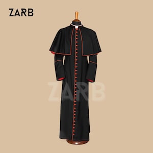 May include: A black cassock with a red trim and a red button closure. The cassock has a cape attached to the back.