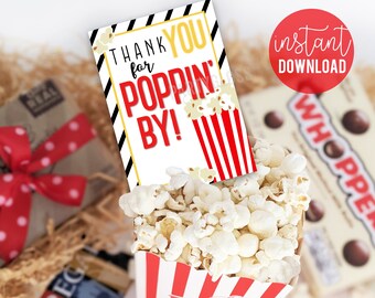 May include: A red and white striped popcorn box with a thank you tag that says "Thank you for poppin' by!" The tag has black and gold stripes and a popcorn graphic.