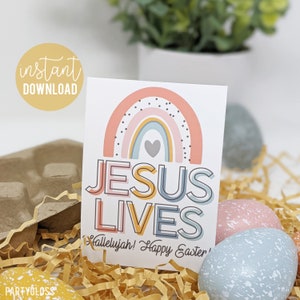 Puede incluir: Una tarjeta de Pascua imprimible con un arcoíris y el texto "Jesús vive" en letras de colores. La tarjeta también incluye el texto "¡Aleluya! ¡Feliz Pascua!" en letras más pequeñas.