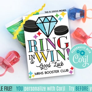 Op de afbeelding: Een printbare tag van 2,5 x 3,5 inch met een kleurrijk ontwerp met een diamanten ring, hockeypucks en de tekst "Ring in a Win! Good Luck" met het logo van de MRHS Booster Club. De tag is aanpasbaar met de tekst "Personaliseer met Corjl".