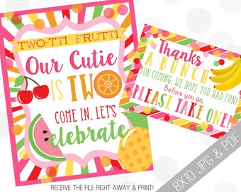 May include: Two vibrant party signs with fruit illustrations and text. One sign reads "Two-tti Frutti, Our Cutie is Two, Come in, Let's Celebrate." The other says "Thanks a Bunch, Please Take One!" with a banana graphic.