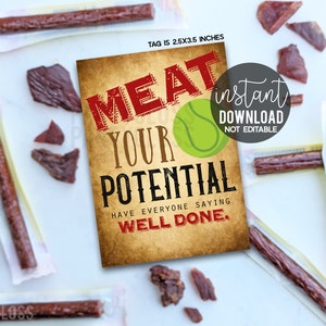 Op de afbeelding: Afdrukbare tag van 2,5 x 3,5 inch met een vintage achtergrond met de tekst "MEAT YOUR POTENTIAL" in rode en witte letters. De tekst "HAVE EVERYONE SAYING WELL DONE." staat in zwarte letters. Een groene tennisbal bevindt zich tussen de woorden "MEAT" en "YOUR". De tag is gemarkeerd met "direct downloaden, niet bewerkbaar".