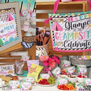 May include: A pink and green welcome sign with the text "Happy Glampers to the Glampsite Let's Celebrate". The sign is decorated with a pink tent, green trees, and gold glitter. There are also several other signs with camping-themed text, such as "S'mores Bar", "Take a Hike", and "Campfire Candy".
