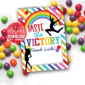 May include: A colorful printable tag with a rainbow, a gymnast silhouette, and the text "Taste the Victory! Good Luck!" The tag is 2.5 inches by 3.5 inches.