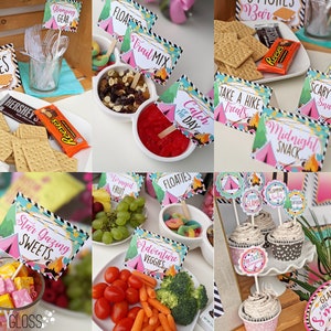 May include: A camping-themed party food table with various snacks and desserts. The table is decorated with pink and green tent-shaped signs with text such as "S'mores Bar", "Trail Mix", "Catch of the Day", "Midnight Snack", "Scary Story Snacks", "Star Gazing Sweets", "Adventure Veggies", "Foraged Fruit", "Floaties", and "Glampers Have S'more Fun".