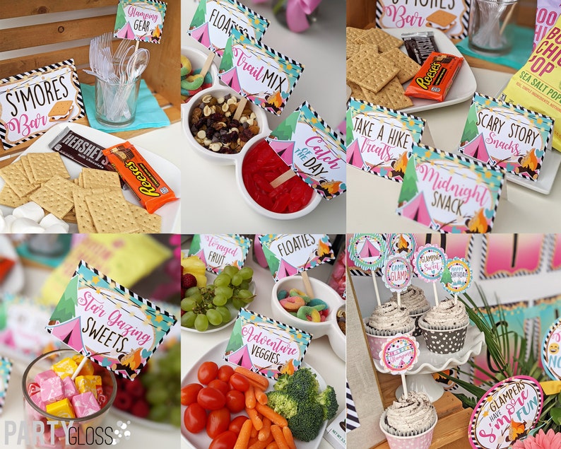 May include: A camping-themed party food table with various snacks and desserts. The table is decorated with pink and green tent-shaped signs with text such as "S'mores Bar", "Trail Mix", "Catch of the Day", "Midnight Snack", "Scary Story Snacks", "Star Gazing Sweets", "Adventure Veggies", "Foraged Fruit", "Floaties", and "Glampers Have S'more Fun".
