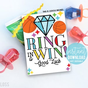May include: A colorful printable tag with the text "Ring in a Win! Good Luck" and a diamond graphic. The tag is 2.5x3.5 inches and features basketballs and stars. The tag is designed for a party favor or gift.