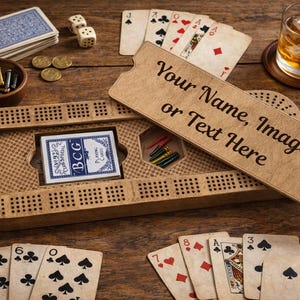 Op de afbeelding: Een houten cribbagebord met speelkaarten, dobbelstenen en een glas whisky. Het bord heeft een vak voor kaarten en pinnen. De tekst "Your Name, Image or Text Here" staat op een houten bord.