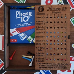 Peut inclure: Un plateau de jeu en bois pour le jeu de cartes Phase 10. Le plateau comporte une grille de cercles avec des points de différentes couleurs pour suivre les phases du jeu. Le plateau comprend également les instructions du jeu, y compris la définition d'un set et d'une course.