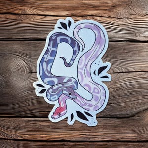 Może przedstawiać: Biały ceramiczny kubek z czarnym uchwytem i napisem "But First, Coffee" czarną, odręczną czcionką. Kubek stoi na białej powierzchni.