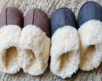 May include: Three pairs of fuzzy slippers. One pair is brown, one pair is gray, and one pair is dark blue. All three pairs have a white faux fur lining.