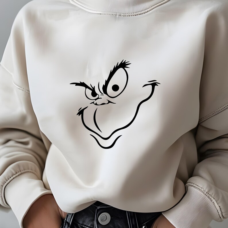 May include: A white sweatshirt with a black Grinch-like face graphic printed on the front.