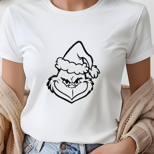 May include: White t-shirt with a black and white illustration of the Grinch wearing a Santa hat.