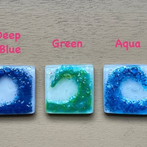 May include: Three square glass tiles with wave designs in Deep Blue, Green, and Aqua. Each tile features a white background with a wave created from small, colorful glass pieces. The words "Deep Blue", "Green", and "Aqua" are written above each tile.