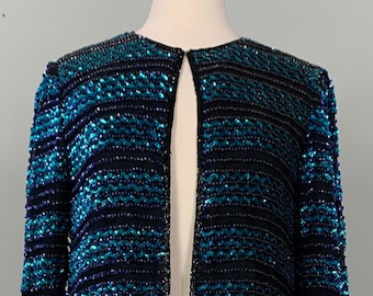 May include: A black and teal sequined jacket with a long-sleeved design and a front opening.