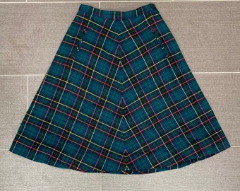 May include: A green, yellow, red, and blue plaid skirt with a button closure. The skirt is a-line and has a knee-length hem.