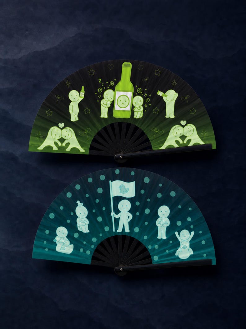 Puede incluir: Dos abanicos plegables con varillas negras. El abanico superior es verde oscuro con ilustraciones en verde claro de figuras, una botella y corazones. El abanico inferior es azul verdoso con ilustraciones en azul claro de figuras y una bandera.