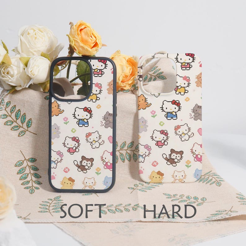 May include: Two phone cases with a repeating pattern of a cartoon cat character in various poses and outfits. The cases are on a cream-colored background with the words "SOFT" and "HARD" printed on the fabric.