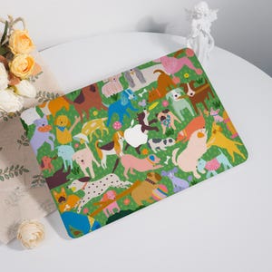 May include: A green laptop skin featuring a playful illustration of various dog breeds in different colors. The design includes bones, flowers, and a white Apple logo. The dogs are in a grassy field.