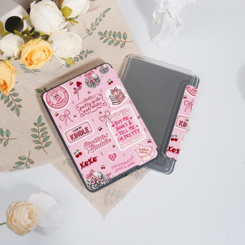 May include: A pink Kindle case with a matching cover. The case is decorated with stickers that say "pretty girls read books", "I love my Kindle", and "Buy me books & tell me I'm pretty". The case is approximately 15 cm long and 10 cm wide.