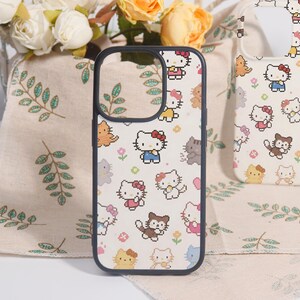May include: A black phone case featuring a repeating pattern of cartoon cats in various poses and outfits. The design includes cats with red bows, dresses, and other accessories. The case is set against a floral background.