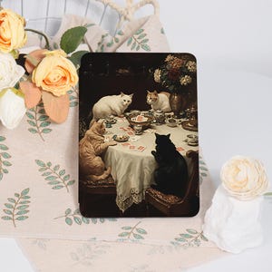 May include: A rectangular tablet case featuring a classic oil painting of four cats sitting around a round table playing cards. The scene includes a white cat, a ginger cat, a black cat, and a white and ginger cat, with tea cups and a vase of flowers.