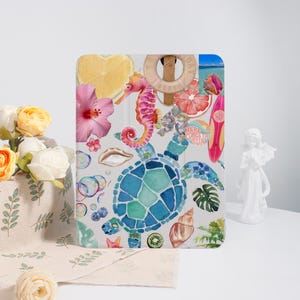 May include: A tablet case featuring a watercolor design with a sea turtle, seahorse, hibiscus flower, and a surfboard. The design includes the text "Here Comes the Sun" and other tropical elements.