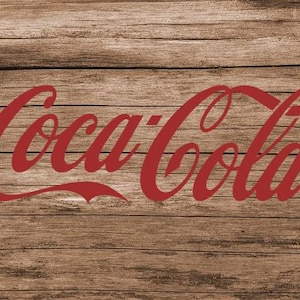 May include: The Coca-Cola logo in red script on a woodgrain background.