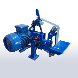 Puede incluir: Una lijadora de banda azul con un gran motor eléctrico. La máquina tiene una banda de lijado, un soporte de trabajo y varias perillas de ajuste. El marco de metal está pintado de azul.
