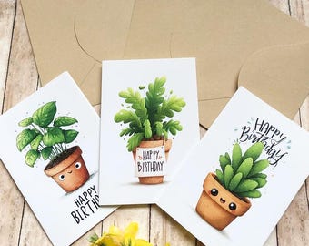 May include: Three white greeting cards featuring illustrations of potted plants with faces and the text Happy Birthday, accompanied by three light brown envelopes. Each card displays a different green plant in a terracotta pot with a smiling face.