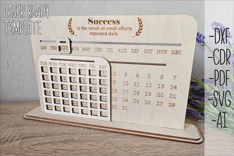 K&ouml;nnte beinhalten: Ein h&ouml;lzerner Schreibtischkalender mit einem monatlichen Kalenderrraster und einem motivierenden Zitat: "Erfolg ist das Ergebnis kleiner Anstrengungen, die t&auml;glich wiederholt werden."