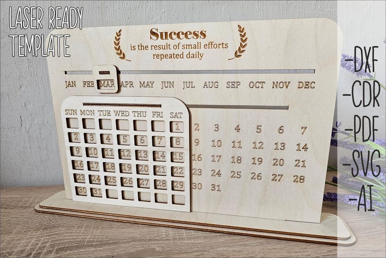 K&ouml;nnte beinhalten: Eine lasergeschnittene Holzkalender-Vorlage mit einem Zitat &uuml;ber Erfolg. Der Kalender verf&uuml;gt &uuml;ber ein monatliches Raster mit Wochentagen und den Zahlen 1-31. Das Zitat lautet "Erfolg ist das Ergebnis kleiner Anstrengungen, die t&auml;glich wiederholt werden".