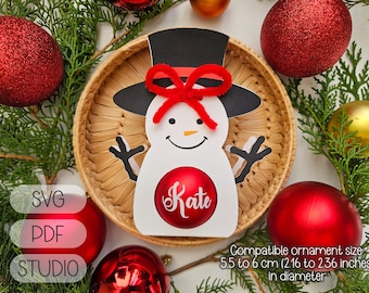 May include: A white snowman ornament with a red bow and a red ball with the name "Kate" written on it. The ornament is compatible with 5.5 to 6 cm (2.16 to 2.36 inches) diameter ornaments.