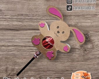 May include: A digital download of a printable bunny lollipop holder template. The template is brown with pink ears and paws. The template is designed to hold a lollipop in the center.