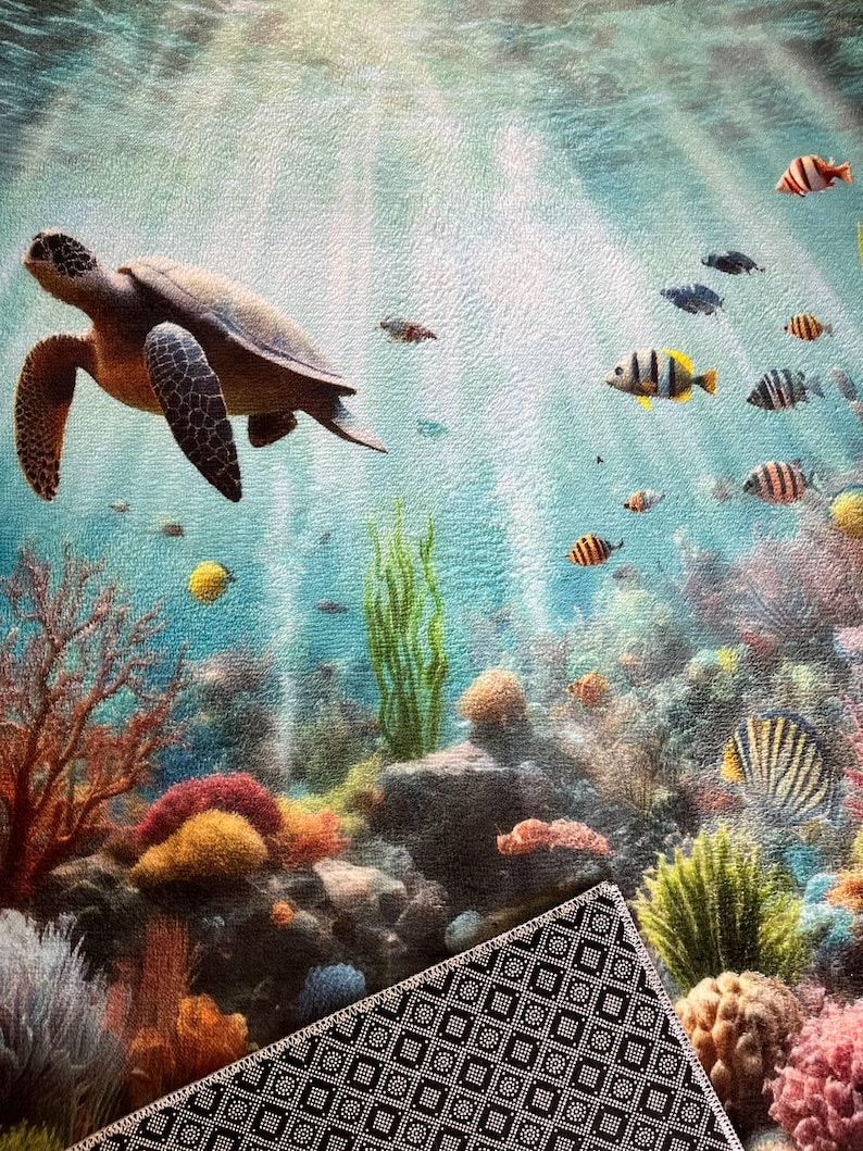 May include: A rectangular mat featuring an underwater scene with a sea turtle swimming among colorful coral reefs, green seaweed, and various small fish. The surface has a textured finish, and the underside shows a black and white geometric pattern.
