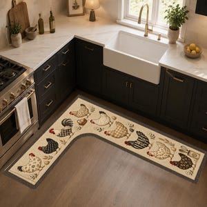 May include: An L-shaped kitchen floor mat featuring a cream-colored background with a repeating pattern of various chickens, eggs, and small floral accents. The mat has a dark gray border and is positioned on a wooden floor in a kitchen setting.