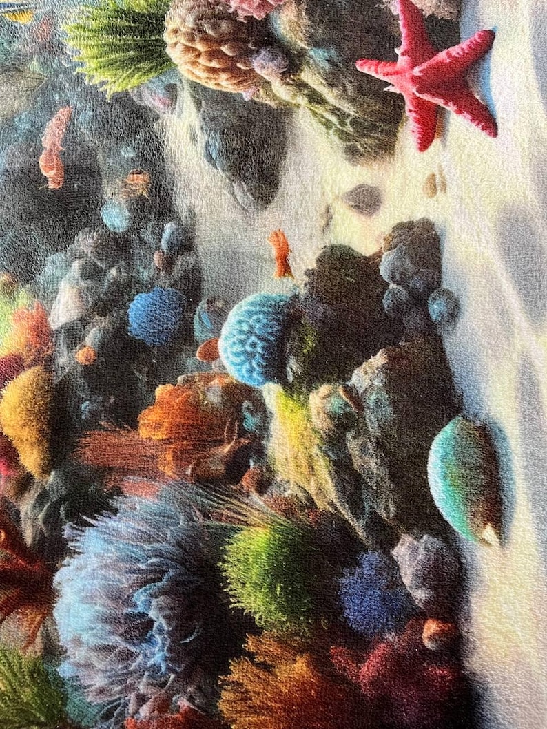 May include: A fabric print featuring a vibrant underwater coral reef scene. The design displays a variety of colorful corals in shades of blue, orange, yellow, and green, alongside a bright red starfish resting on a sandy ocean floor.