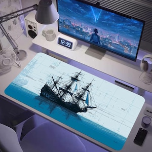 Puede incluir: Alfombrilla de ratón rectangular con una ilustración detallada de un velero alto navegando sobre agua azul. El barco es negro y el fondo es azul claro con dibujos técnicos tenues. Se ven un monitor de ordenador y otros accesorios de escritorio.