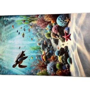 May include: A rectangular beach towel featuring a vibrant underwater scene with a sea turtle swimming in clear blue water. The design includes a colorful coral reef, various small tropical fish, and a bright red starfish on a sandy ocean floor.