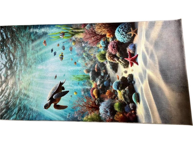 May include: A rectangular beach towel featuring a vibrant underwater scene with a sea turtle swimming in clear blue water. The design includes a colorful coral reef, various small tropical fish, and a bright red starfish on a sandy ocean floor.