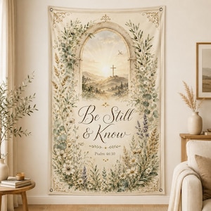 May include: A rectangular wall tapestry featuring a cream background with a central archway framing a landscape with a cross at sunset. The text reads Be Still & Know Psalm 46:10. The design is surrounded by a border of watercolor green foliage and flowers.